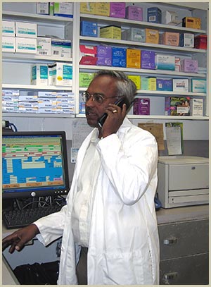 Dr. Apparao Malla assisting a customer by phone inside King-Raj Pharmacy